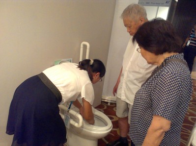 鷹衛浴工作人員在給老人家講解適老化衛浴的使用方法